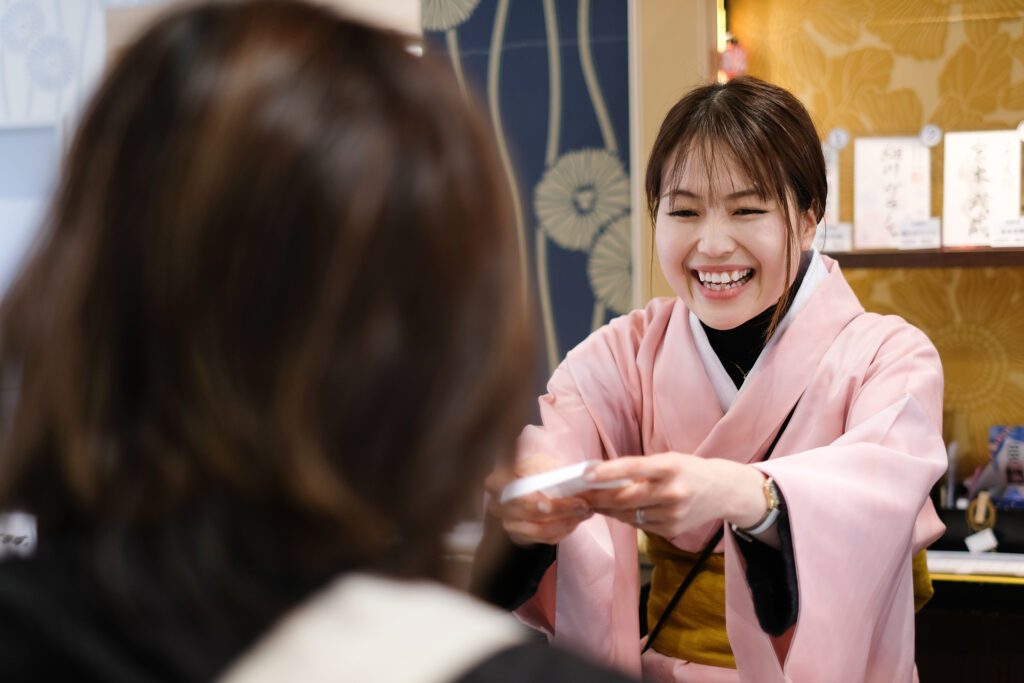 着物姿のスタッフが御城印を手渡す様子